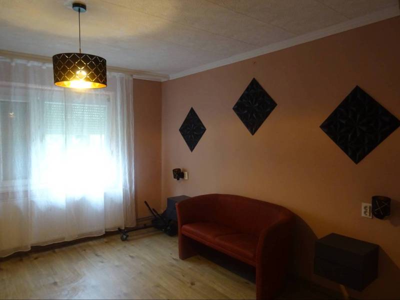 Living room of a family house with a red sofa and curtains on the window.