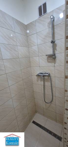 Shower corner with tiles in a studio apartment, without decorations and rugs.