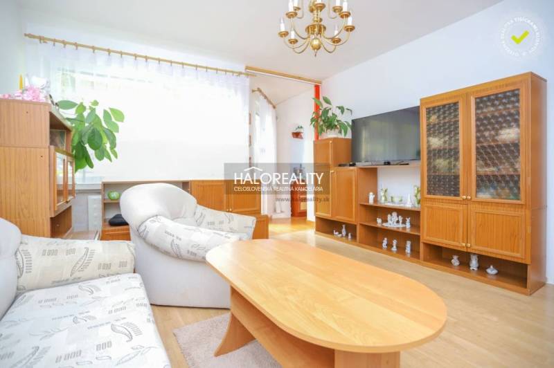 Living room of a three-room apartment with wooden furniture and comfortable seating.