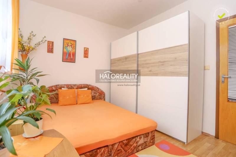 Bedroom in a 3-room apartment with an orange bed and a large wardrobe.