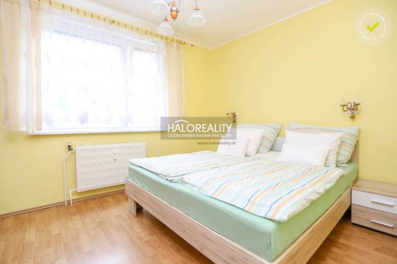 Bright bedroom with a double bed and wooden flooring in a 3-room apartment.