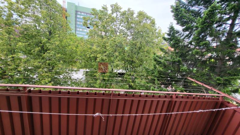 The view from the balcony of a 3-room apartment on Joliot Curie Street in Poprad, full of trees.