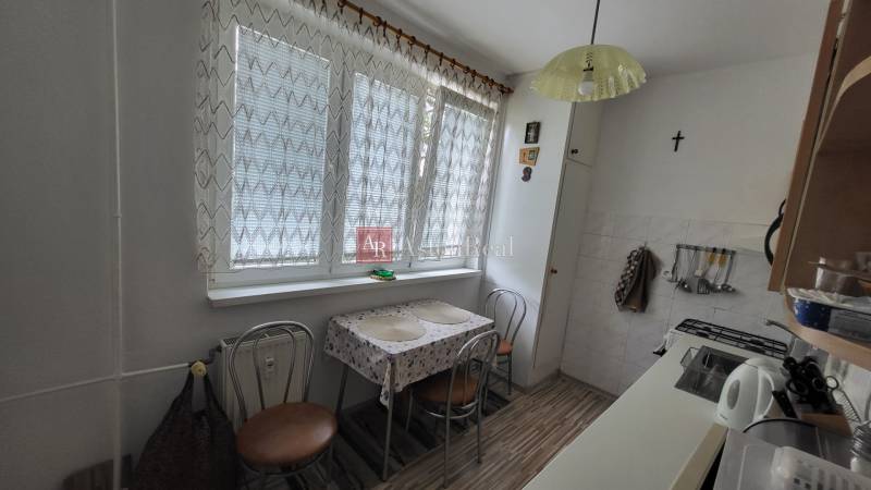 Kitchen in a 3-room apartment with a small table, chairs, and kitchen accessories.