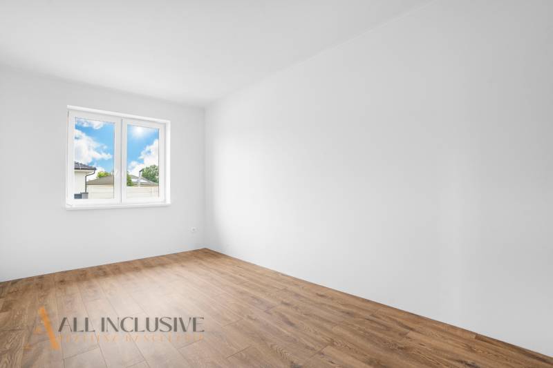 An empty room in a family house with white walls and wooden floor.