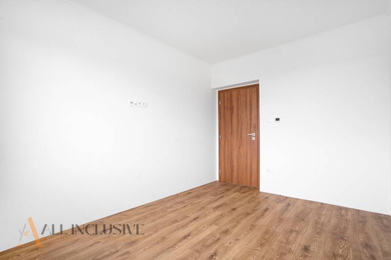 Empty room in a family house with white walls and wooden floor.
