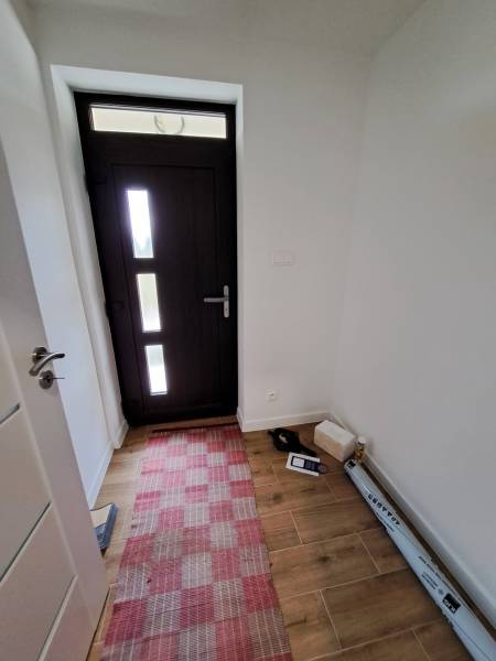 Entrance hall in a family house with dark doors and a red carpet.