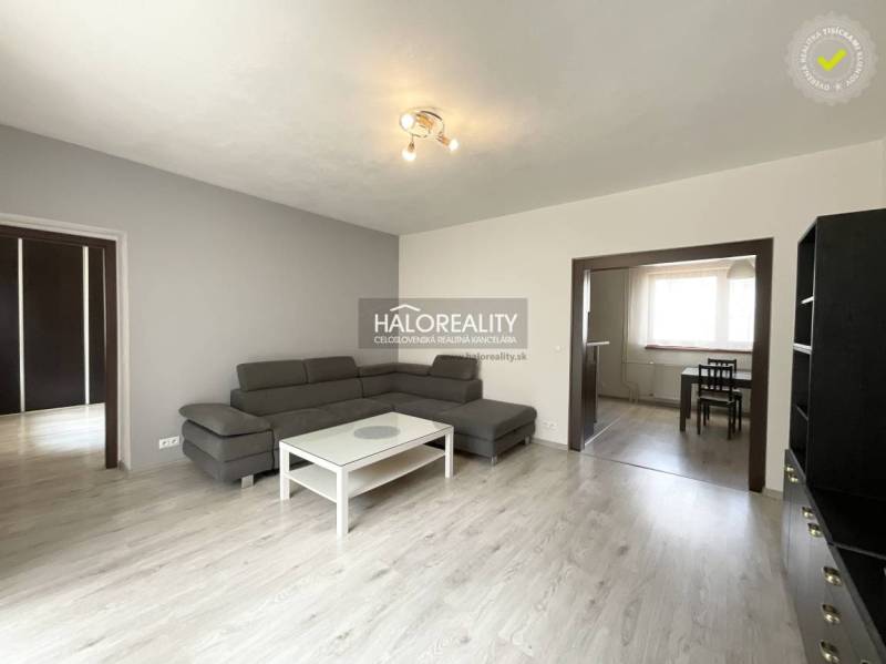 Living room in a family house with a gray sofa and a white table.
