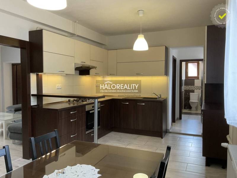 A kitchen unit with a dining table in a family house, including bright lighting and tiles.