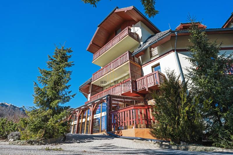 A building with wooden balconies surrounded by trees on Donovaly Street in Donovaly.