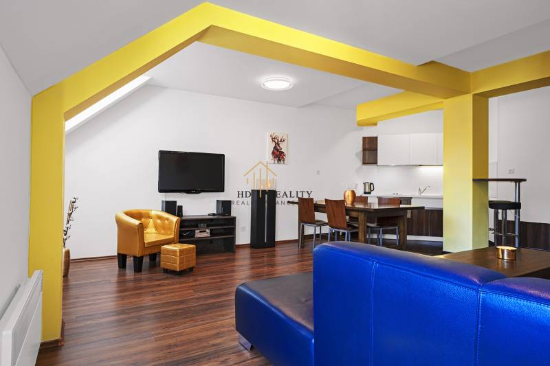 A bright interior of a 2-room apartment with yellow elements, a kitchen, and a seating area.