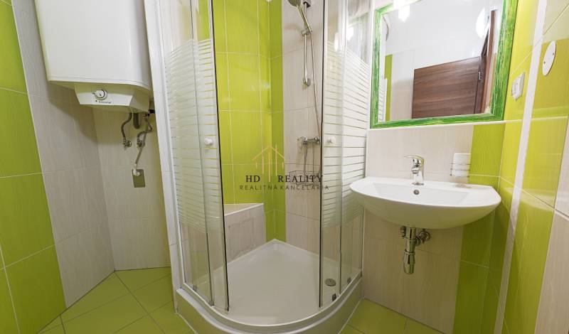Renovated bathroom in a 2-room apartment with a bathtub, shower, and sink.