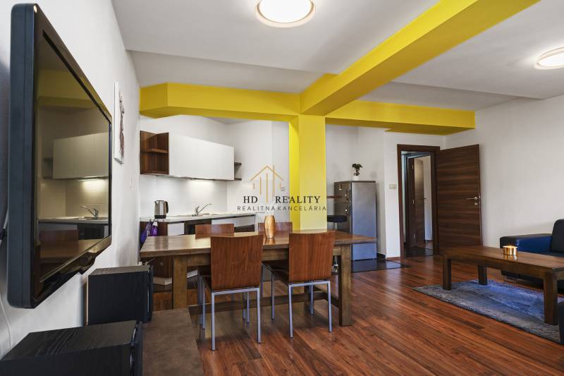 Living room in a two-room apartment with wooden furniture and yellow columns.