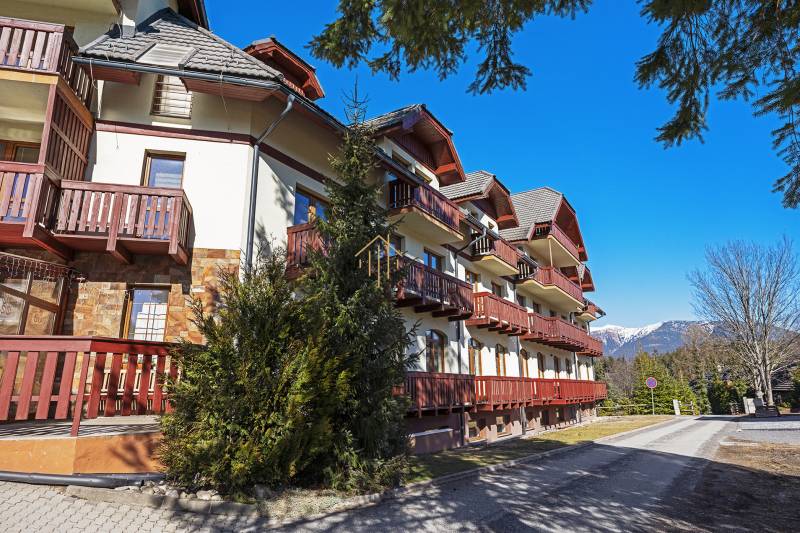 Exterior of a 2-bedroom apartment in Donovaly with balconies and a mountain backdrop.