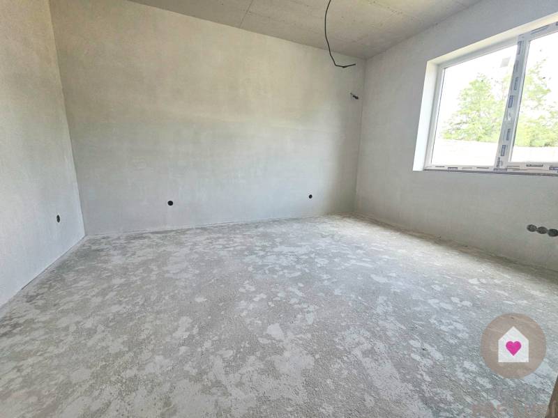 An unfinished room with a window in a family house waiting for interior completion.