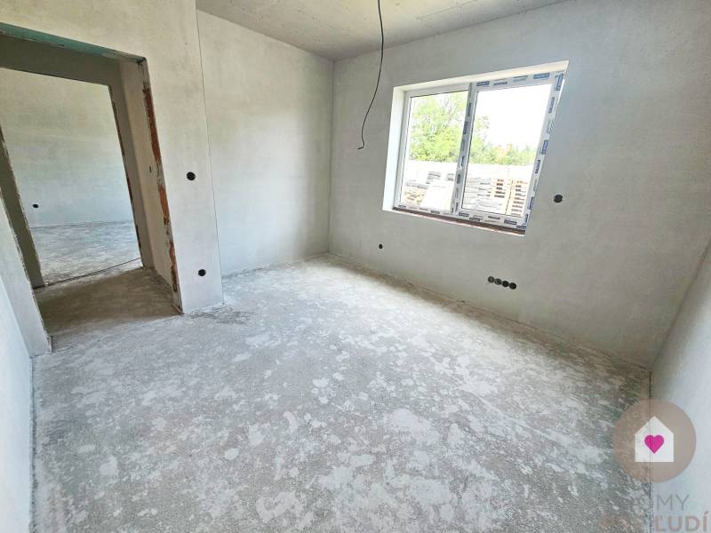Empty room in a family house with unfinished walls and a concrete floor.