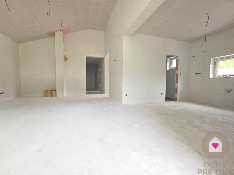 A view of an unfinished interior in a family house with white walls and floor.