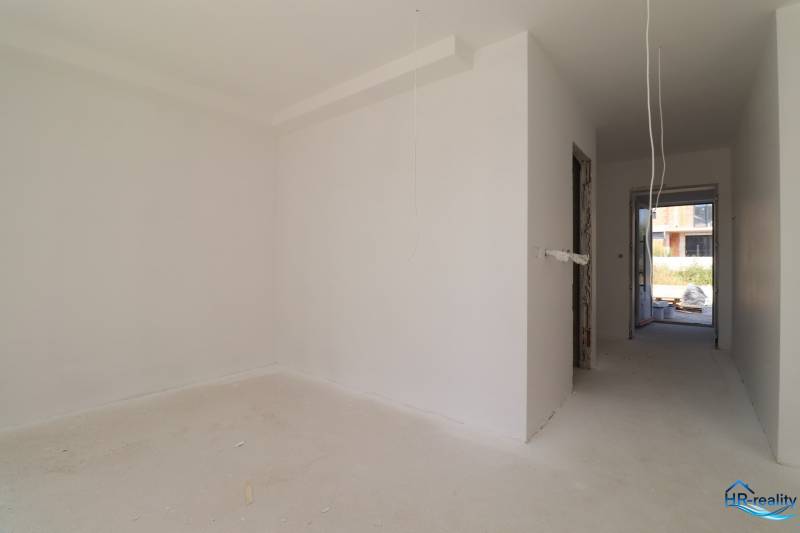 An unfinished room in a holiday apartment with white walls and electrical installation preparation.