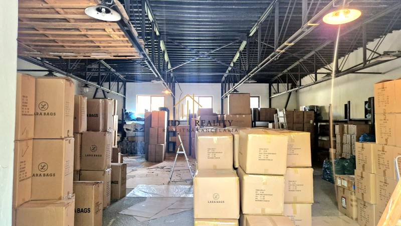 Warehouses and halls full of boxes and goods with metal ceiling beams.