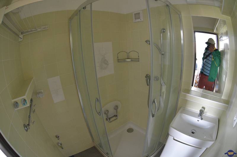 A bathroom with tiles and a shower in a 2-room apartment.