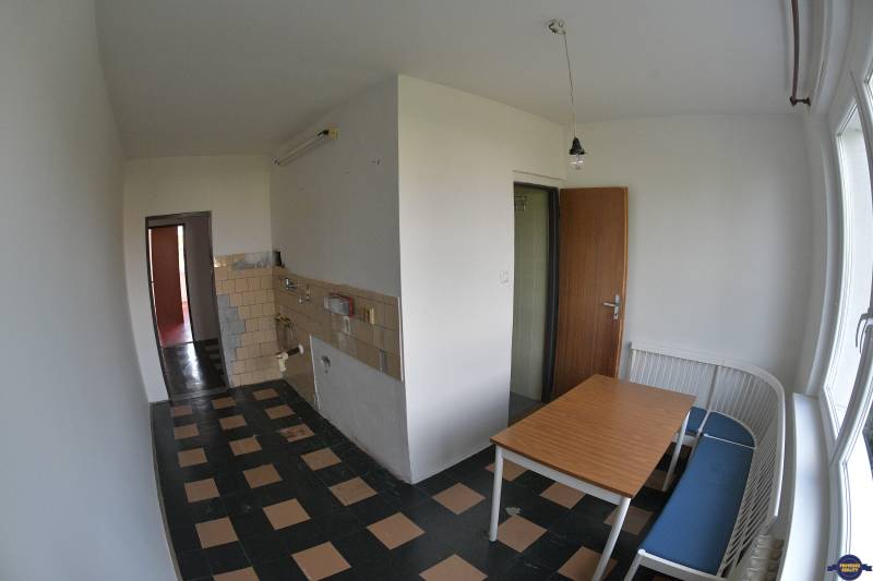 Dining room in a 2-room apartment with a dining table and a bench by the window.