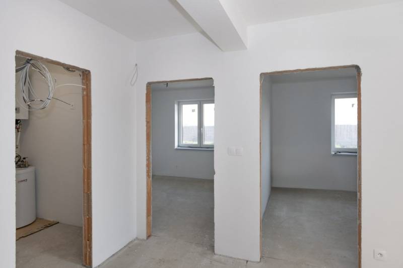 Interior of a family house with unfinished rooms and white walls.