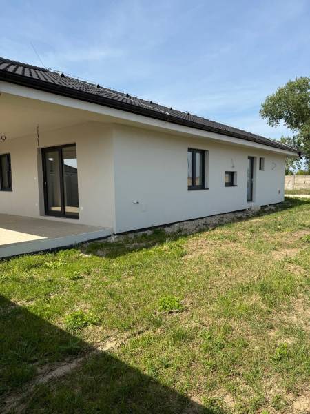 A family house in Galanta Košúty, with a white facade and a sloped roof on a grassy area.