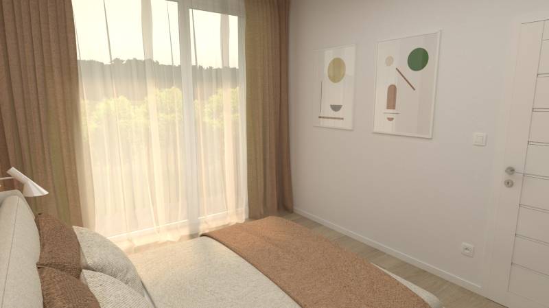 A bedroom in a two-room apartment with a bed, paintings, and curtains by the window.
