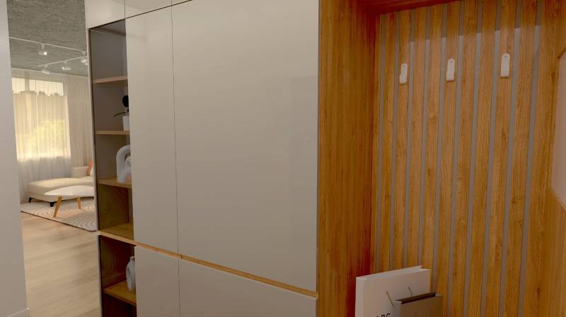 Built-in wardrobe and wooden hangers in the hallway of a 2-room apartment, view into the living room.
