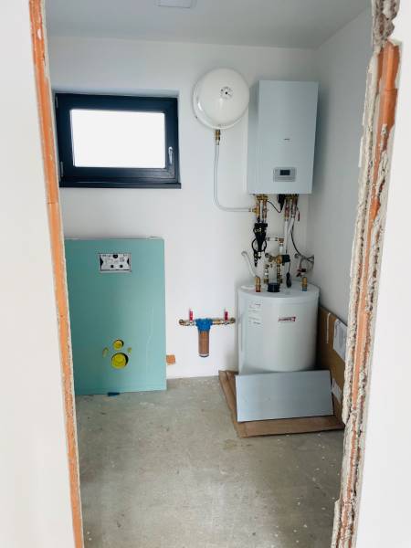 Technical room in a family house with a boiler and a water tank.