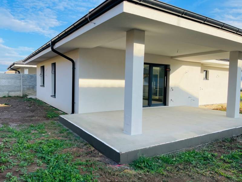 A family house in Kynek near Nitra with a terrace, lawn, and fence on a spacious plot.