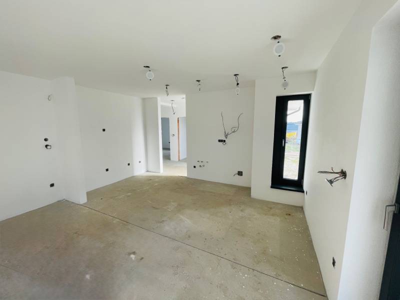 Empty room with a window and white walls in a family house.