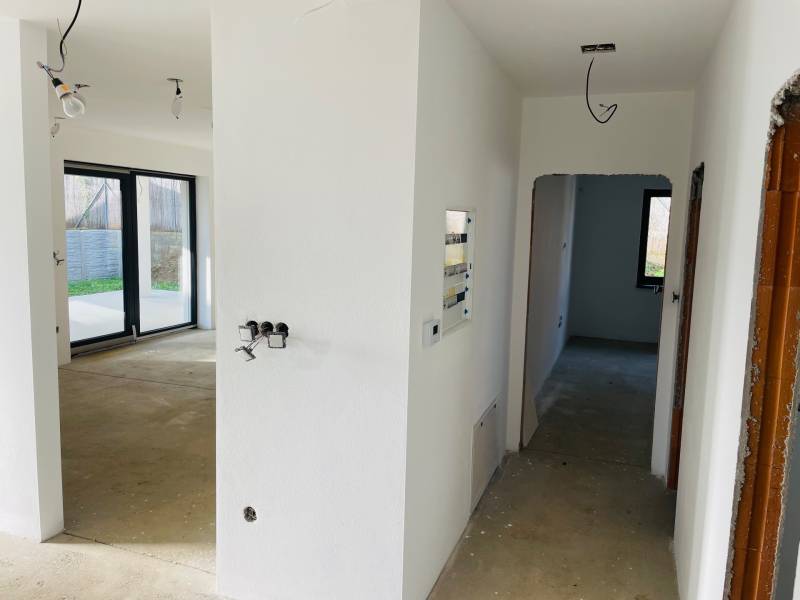 White corridor, electrical installation, large windows, view inside the family house.