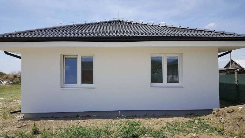 A family house in Western Slovakia with a white facade and a black roof.