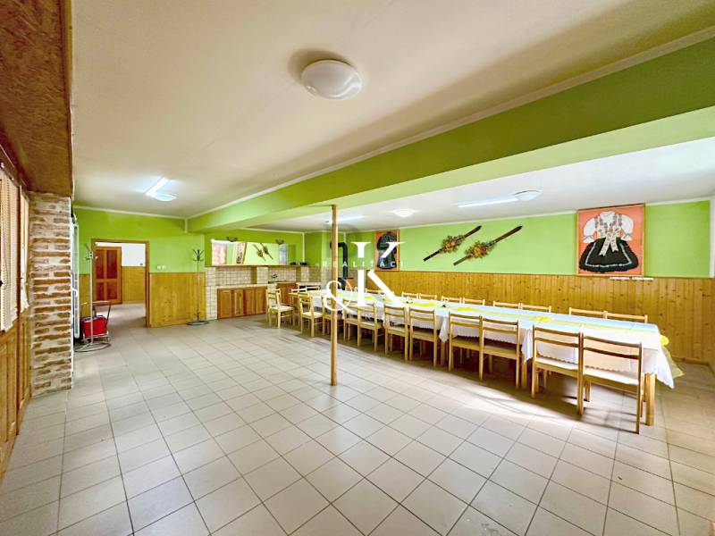 Spacious gastro spaces with wooden furniture and decorations on green walls.