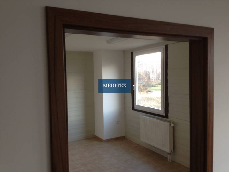 Room with a door frame, window, and radiator in storage and warehouse spaces.