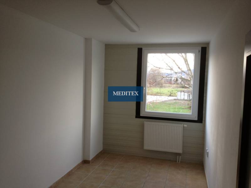 A room with a light floor, tiles, and a radiator, suitable for storage and halls.