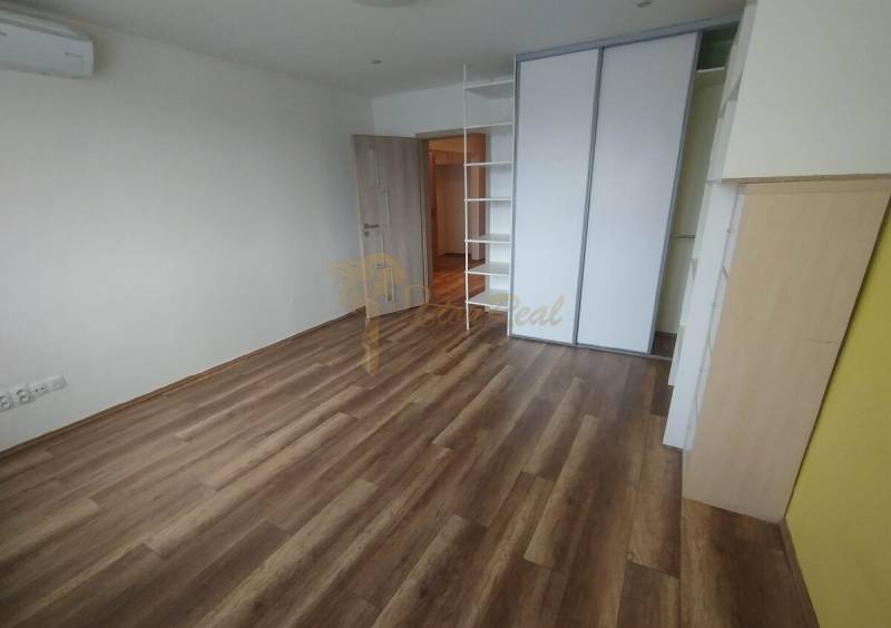 A spacious room with wooden flooring and a built-in wardrobe in a 3-room apartment.