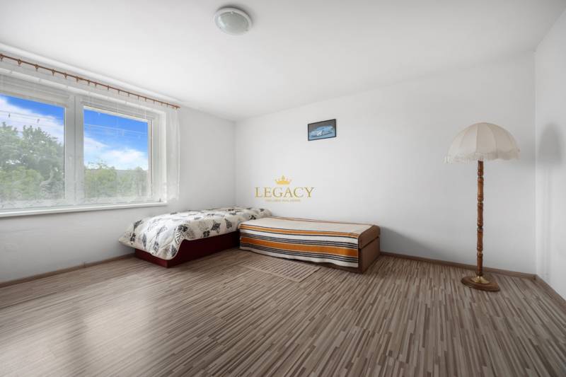 A bright room in a family house with a bed, a lamp, and a view outside.