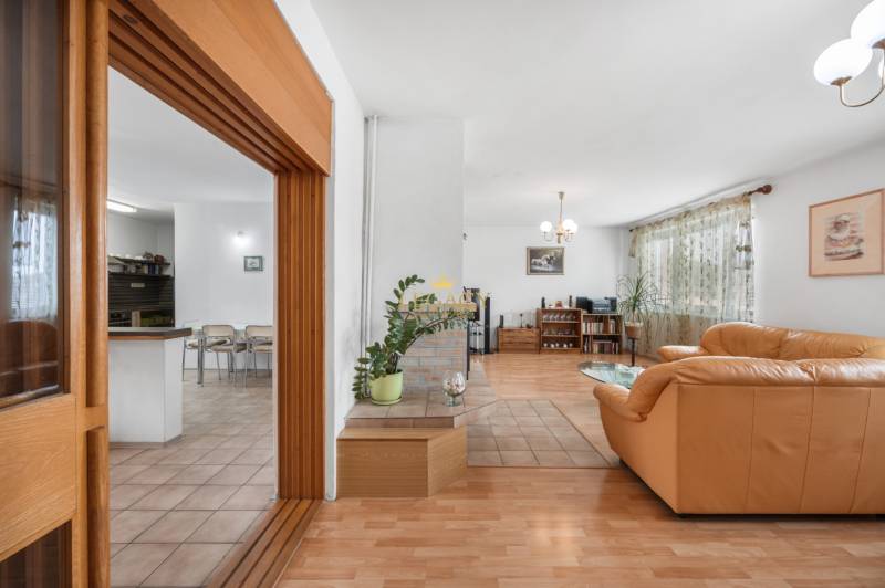 Interior of a family house with a bright living room, comfortable sofa, and dining area.