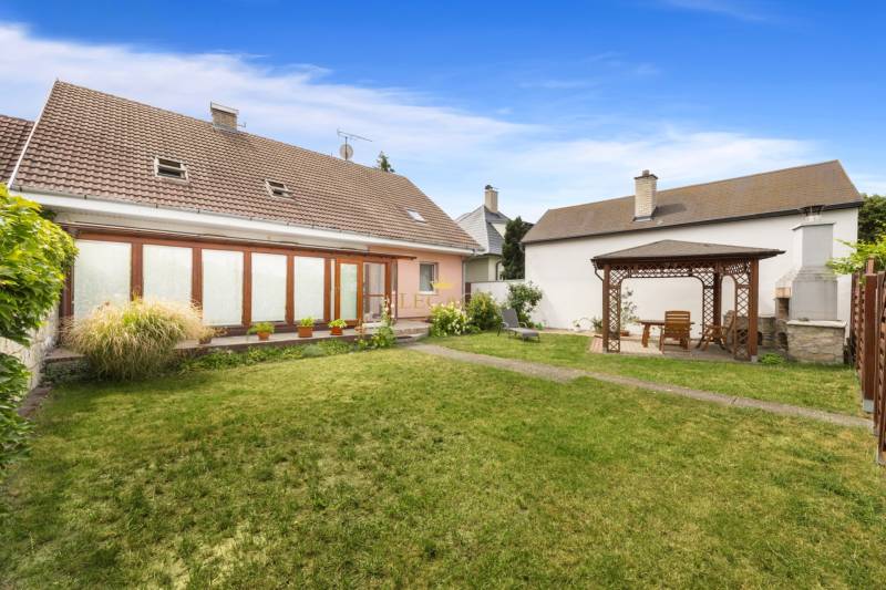 The garden of a family house in Vinosady with a wooden gazebo and a lawn.