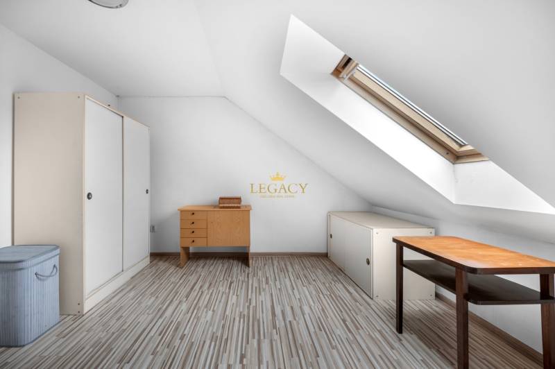 Attic room in a family house with a table and a wardrobe under the skylight.