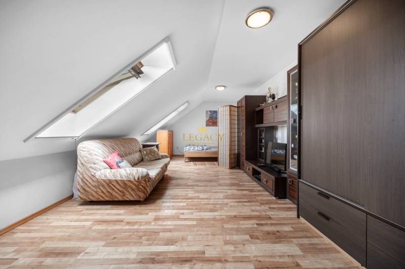 Attic room in a family house with a couch and dark wood furniture.