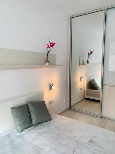 A bright bedroom on Palisády Street with large mirrors in a 2-room apartment.