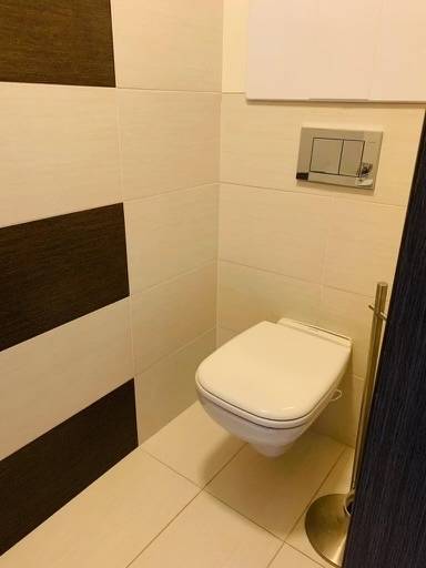 A room with a toilet in a 2-room apartment on Palisády Street, light tiles, dark cladding.