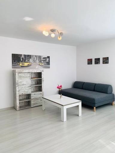 Living room on Palisády Street. Bright 2-room apartment with a sofa and a table.