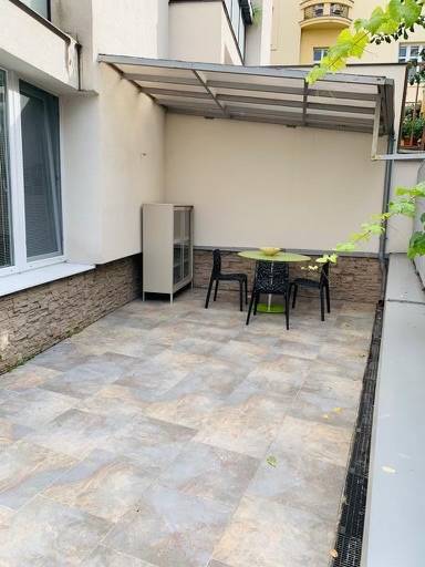 A terrace with tables and chairs in a 2-room apartment on Palisády Street.