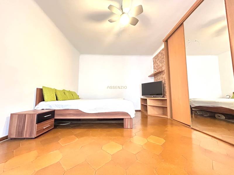 A bedroom in a 3-room apartment with a mirrored wardrobe and a television, reminiscent of a cozy home.