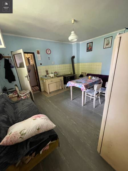 The kitchen of the family house with a tiled stove, table, and sofa is cozily furnished.