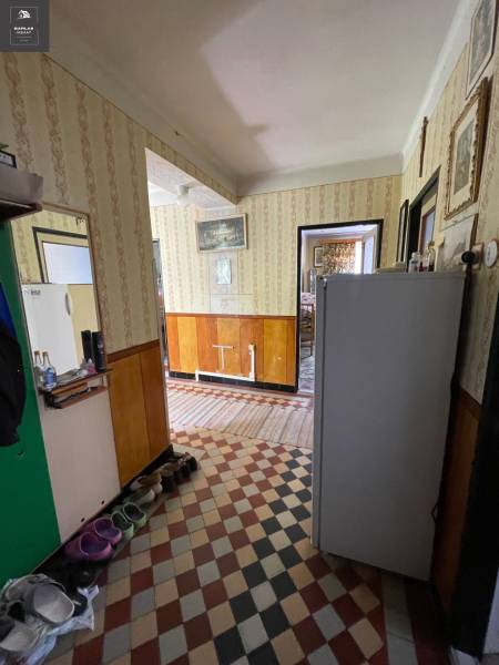 A hallway in a family house with retro wallpaper and a tiled floor.