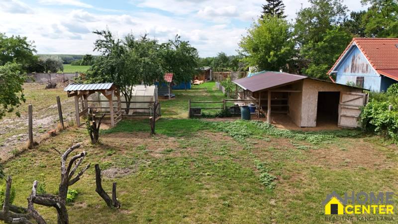 The garden of a family house in Kolárovo with wooden shelters and greenery in the surroundings.